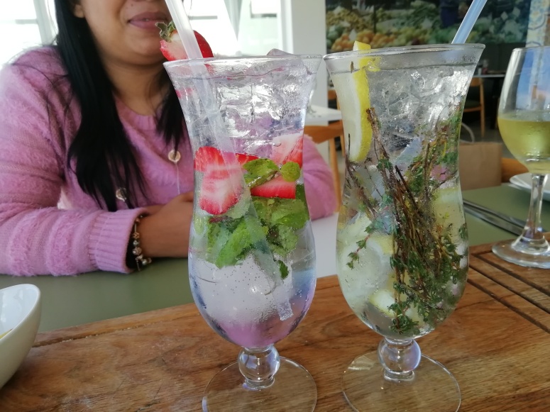 Gin and tonic in tall glasses, girl with pink top behind it